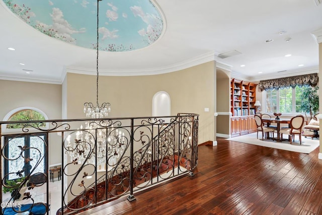 corridor with wood finished floors, baseboards, a chandelier, ornamental molding, and recessed lighting