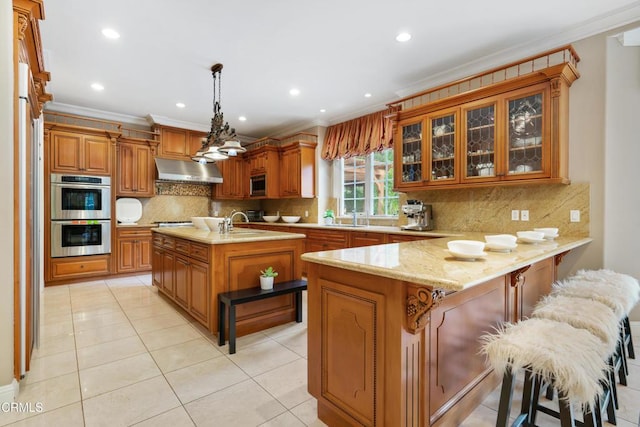 kitchen with brown cabinets, crown molding, a sink, stainless steel appliances, and a peninsula