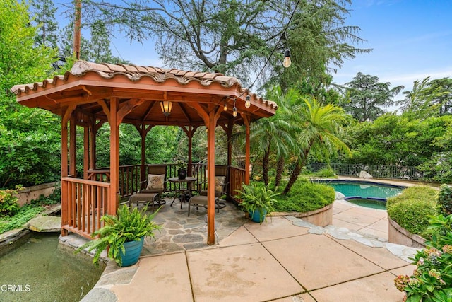view of community with a swimming pool, a gazebo, fence, and a patio