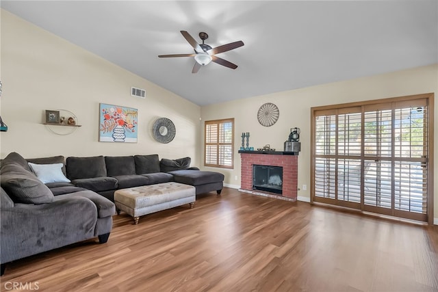 living room with ceiling fan, a fireplace, wood finished floors, and lofted ceiling