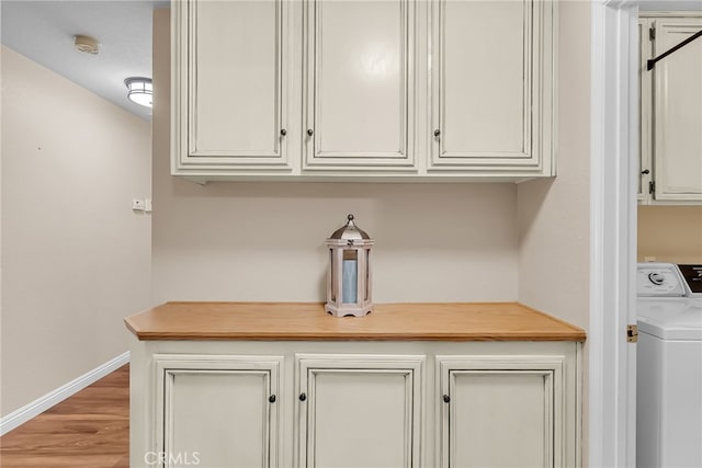 room details with baseboards, washer / clothes dryer, and wood finished floors