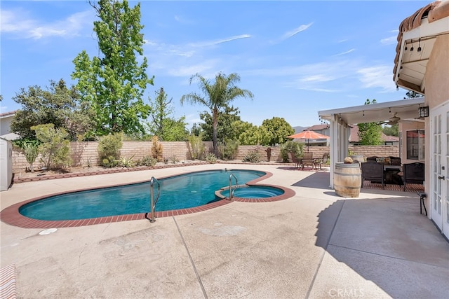 view of swimming pool featuring a patio, a fenced backyard, ceiling fan, and a pool with connected hot tub