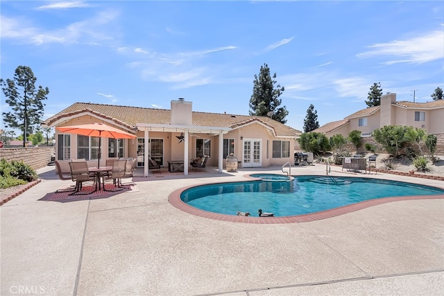 view of swimming pool with french doors, a fenced in pool, an in ground hot tub, and a patio area