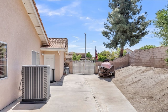 view of patio with a gate, cooling unit, and fence private yard