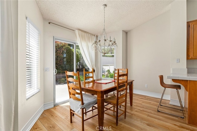 429 Indian Wells Rd, Banning, CA 92220 - dining space featuring a textured ceiling, a chandelier, light wood finished floors, and baseboards