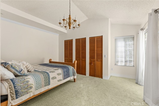 429 Indian Wells Rd, Banning, CA 92220 - carpeted bedroom featuring a chandelier, lofted ceiling, multiple closets, and a textured ceiling
