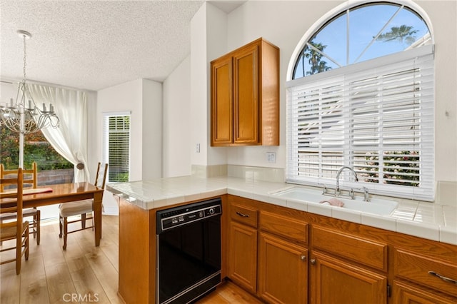 429 Indian Wells Rd, Banning, CA 92220 - kitchen featuring black dishwasher, plenty of natural light, a textured ceiling, brown cabinets, and light wood finished floors