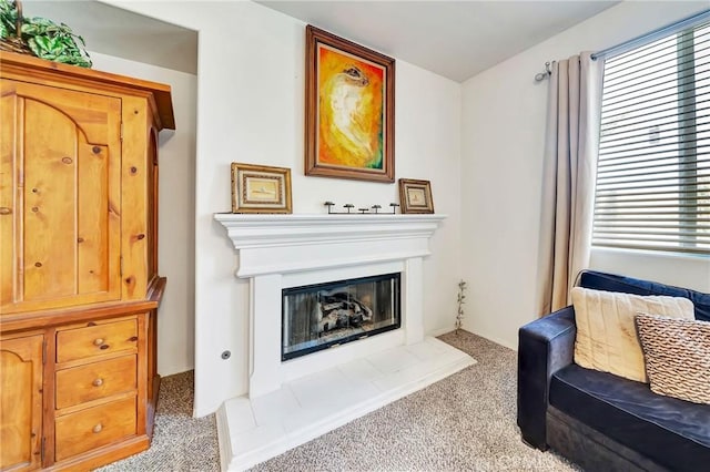 living room featuring plenty of natural light, carpet flooring, and a glass covered fireplace