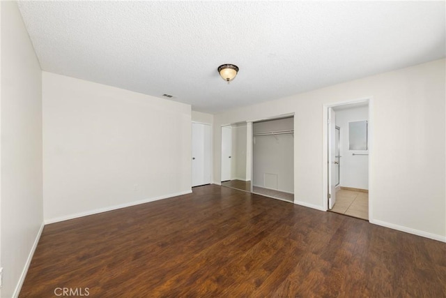 unfurnished bedroom with wood finished floors, baseboards, a closet, and a textured ceiling