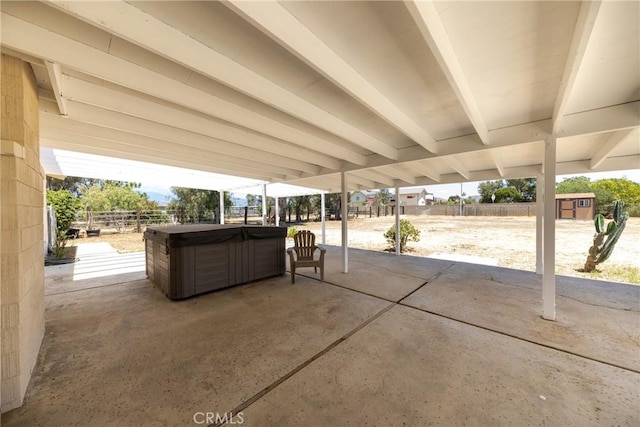 view of patio featuring a hot tub and fence