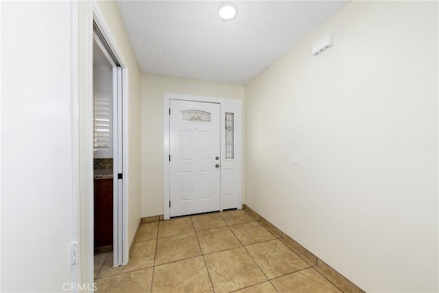 entryway with light tile patterned floors and baseboards