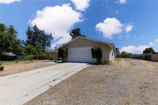 view of front of property with fence, concrete driveway, and an attached garage