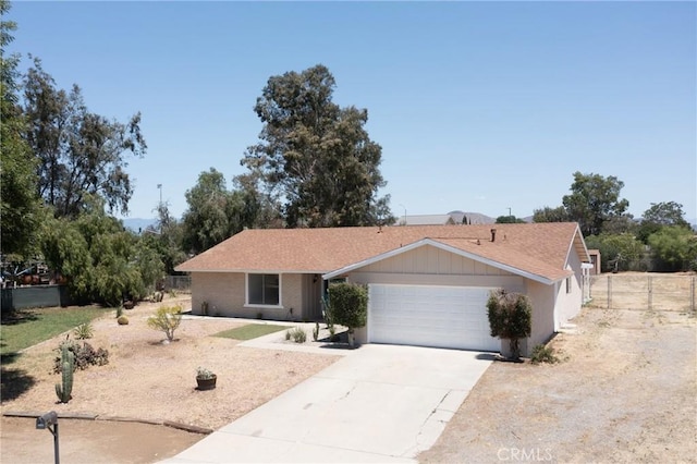single story home featuring an attached garage, driveway, and fence