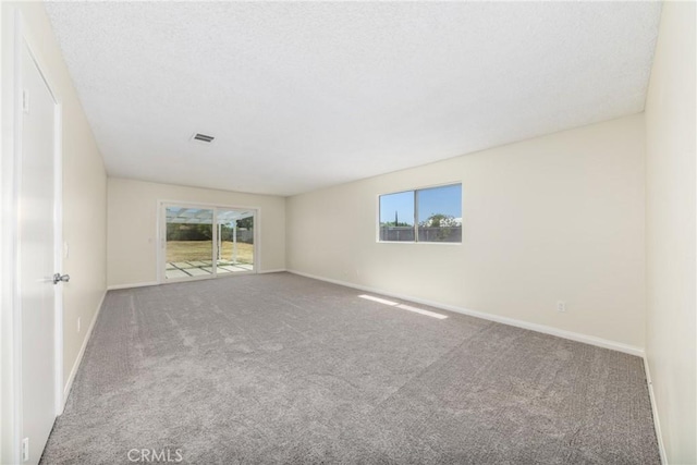 carpeted spare room featuring baseboards