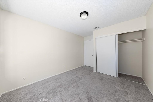 unfurnished bedroom featuring carpet flooring, a closet, and baseboards