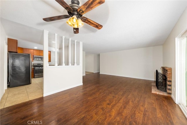unfurnished living room featuring light wood-style flooring, ceiling fan, and baseboards