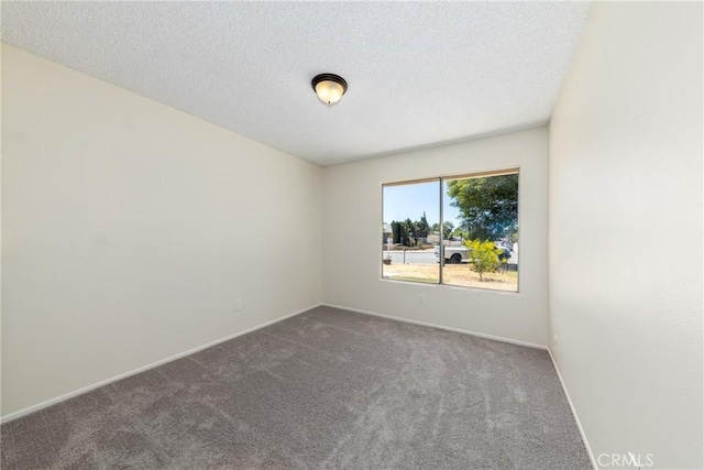 carpeted empty room with baseboards and a textured ceiling
