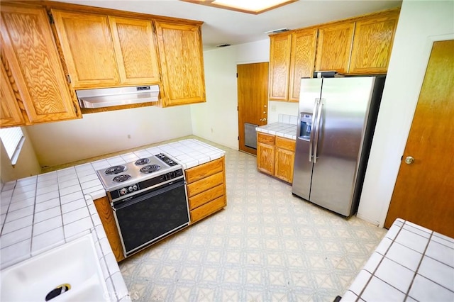 kitchen with electric range, stainless steel fridge with ice dispenser, tile countertops, range hood, and light floors