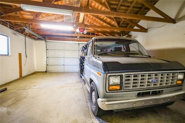 garage with baseboards and a garage door opener