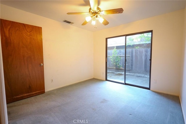 spare room with carpet flooring, ceiling fan, visible vents, and baseboards