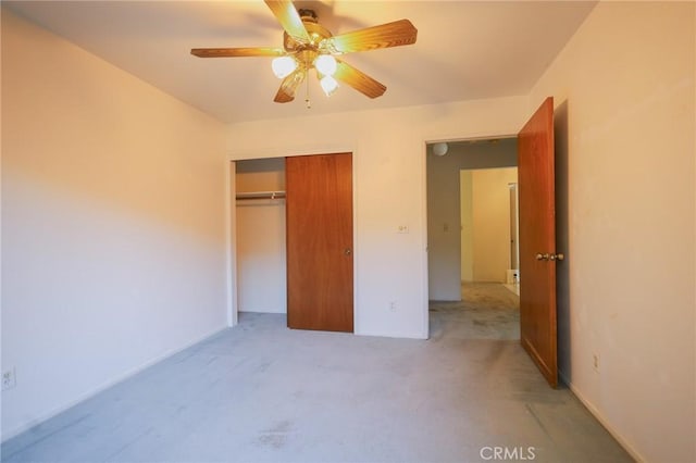 unfurnished bedroom featuring a ceiling fan, a closet, and light colored carpet