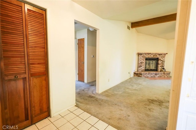 unfurnished living room featuring light tile patterned flooring, light carpet, vaulted ceiling with beams, and a fireplace