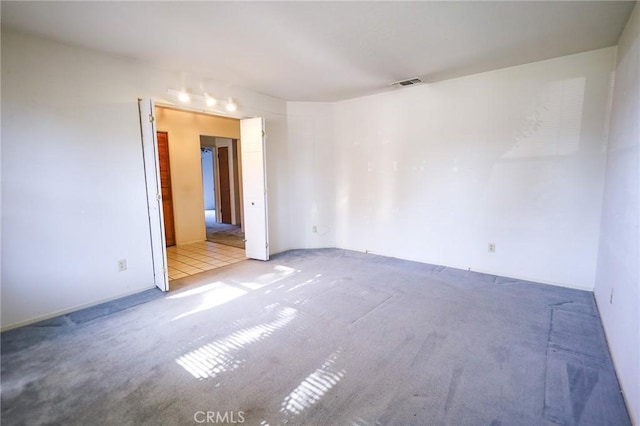 unfurnished room featuring visible vents and carpet floors