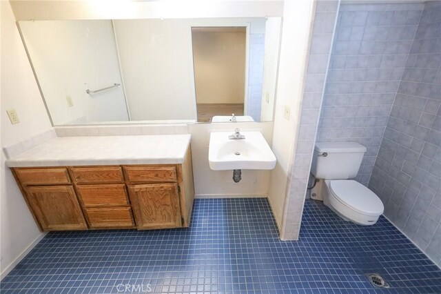bathroom featuring a sink, tile patterned flooring, and toilet