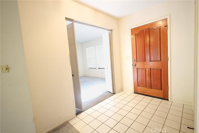 hallway with light tile patterned flooring and light colored carpet