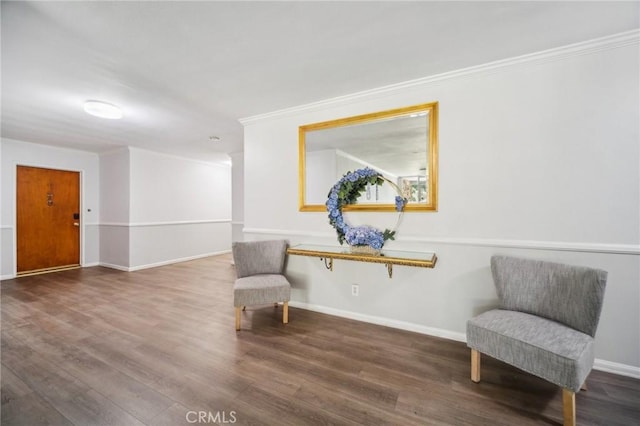 sitting room with baseboards, ornamental molding, and wood finished floors