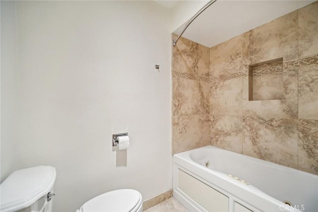 bathroom featuring baseboards, toilet, and tub / shower combination