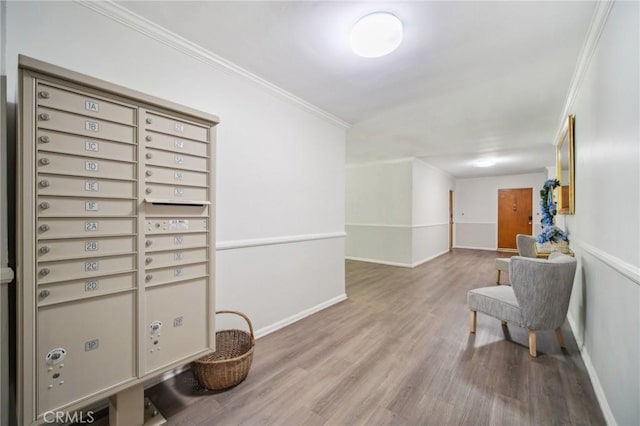 interior space with baseboards, mail area, crown molding, and wood finished floors