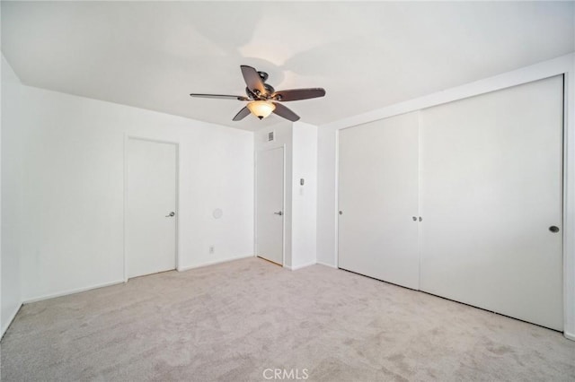 unfurnished bedroom with a closet, ceiling fan, carpet flooring, and visible vents