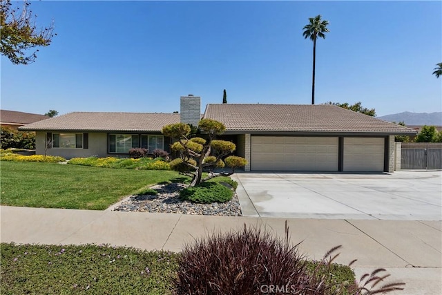5410 Via, San Jacinto, Riverside, CA 92506 - ranch-style house featuring a garage, a chimney, driveway, a tiled roof, and a front lawn