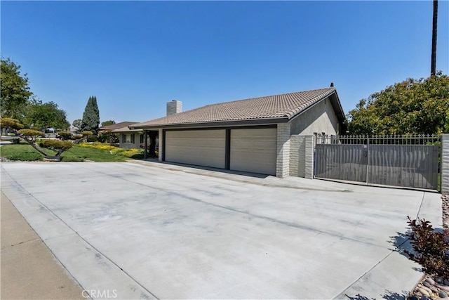 5410 Via, San Jacinto, Riverside, CA 92506 - view of property exterior featuring a garage, a tile roof, concrete driveway, fence, and a chimney