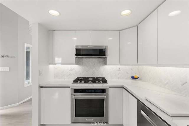 kitchen featuring decorative backsplash, modern cabinets, light countertops, stainless steel appliances, and white cabinetry