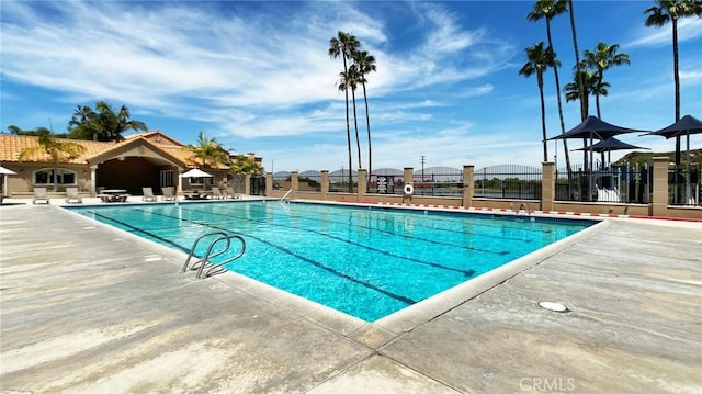 pool featuring fence and a patio area