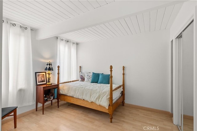 bedroom with wooden ceiling, baseboards, beamed ceiling, and light wood-type flooring