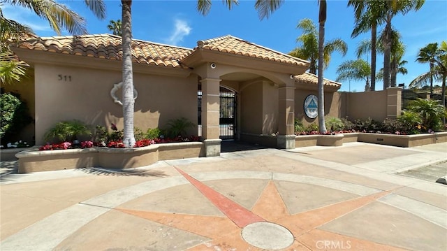 view of front of property featuring a gate, stucco siding, and a tile roof