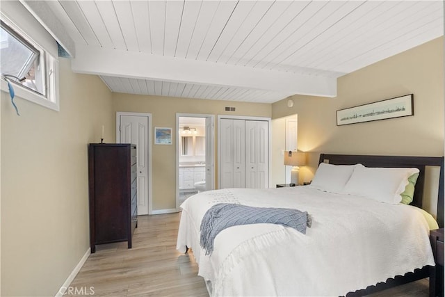 bedroom with visible vents, baseboards, light wood-style flooring, and beam ceiling