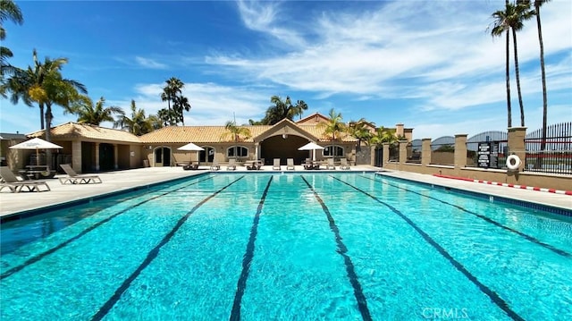 community pool with fence and a patio area