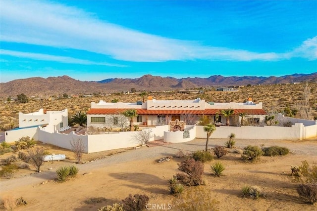 7423 Juniper Rd, Joshua Tree, CA 92252 - rear view of house featuring fence private yard, view of desert, a chimney, a tiled roof, and a mountain view