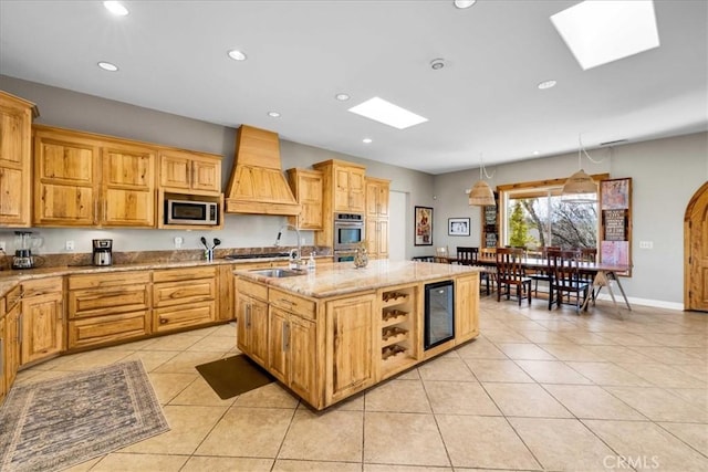7423 Juniper Rd, Joshua Tree, CA 92252 - kitchen with appliances with stainless steel finishes, recessed lighting, light tile patterned floors, custom range hood, and a skylight