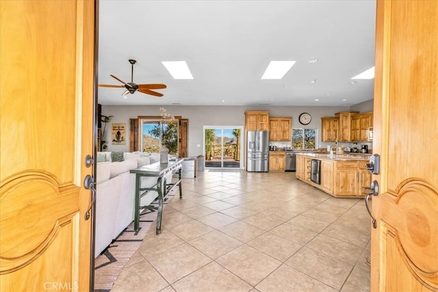 7423 Juniper Rd, Joshua Tree, CA 92252 - kitchen with light tile patterned flooring, open floor plan, light countertops, appliances with stainless steel finishes, and a skylight