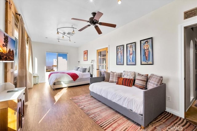 7423 Juniper Rd, Joshua Tree, CA 92252 - bedroom featuring rail lighting, a ceiling fan, baseboards, wood finished floors, and visible vents