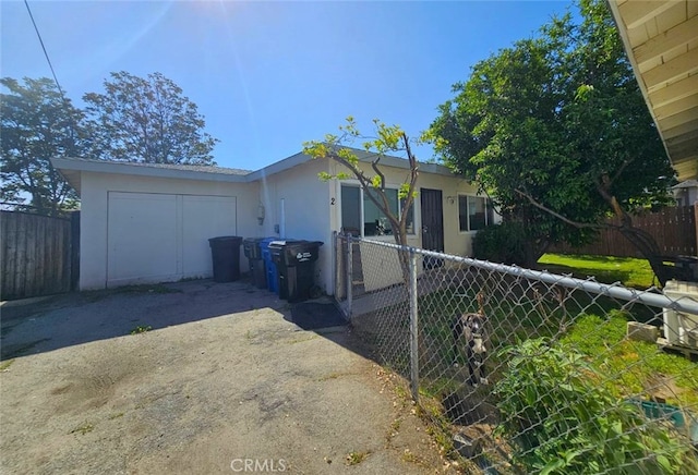1412 S White Ave, Pomona, CA 91766 - view of front of house featuring a garage, stucco siding, driveway, and fence