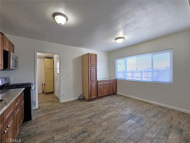 1412 S White Ave, Pomona, CA 91766 - kitchen featuring stainless steel appliances, brown cabinetry, and wood finished floors