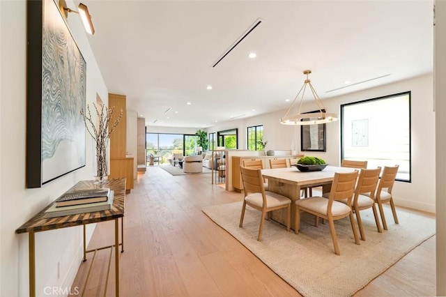 dining space with light wood finished floors and recessed lighting
