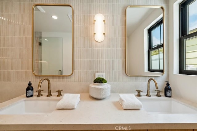 bathroom featuring double vanity, a sink, and a shower