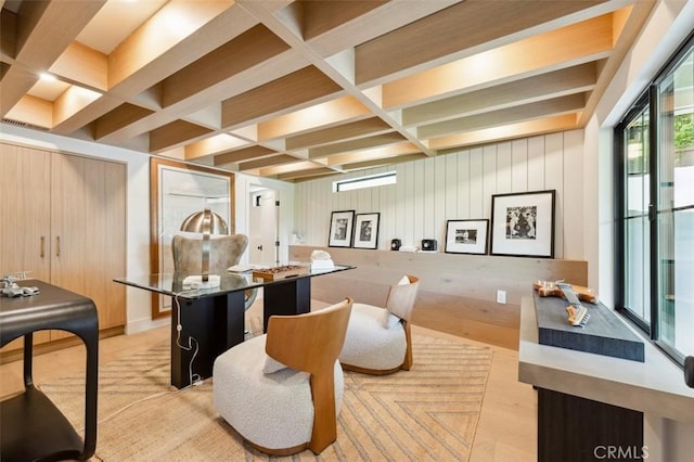 interior space featuring wooden walls, beamed ceiling, coffered ceiling, and light wood finished floors